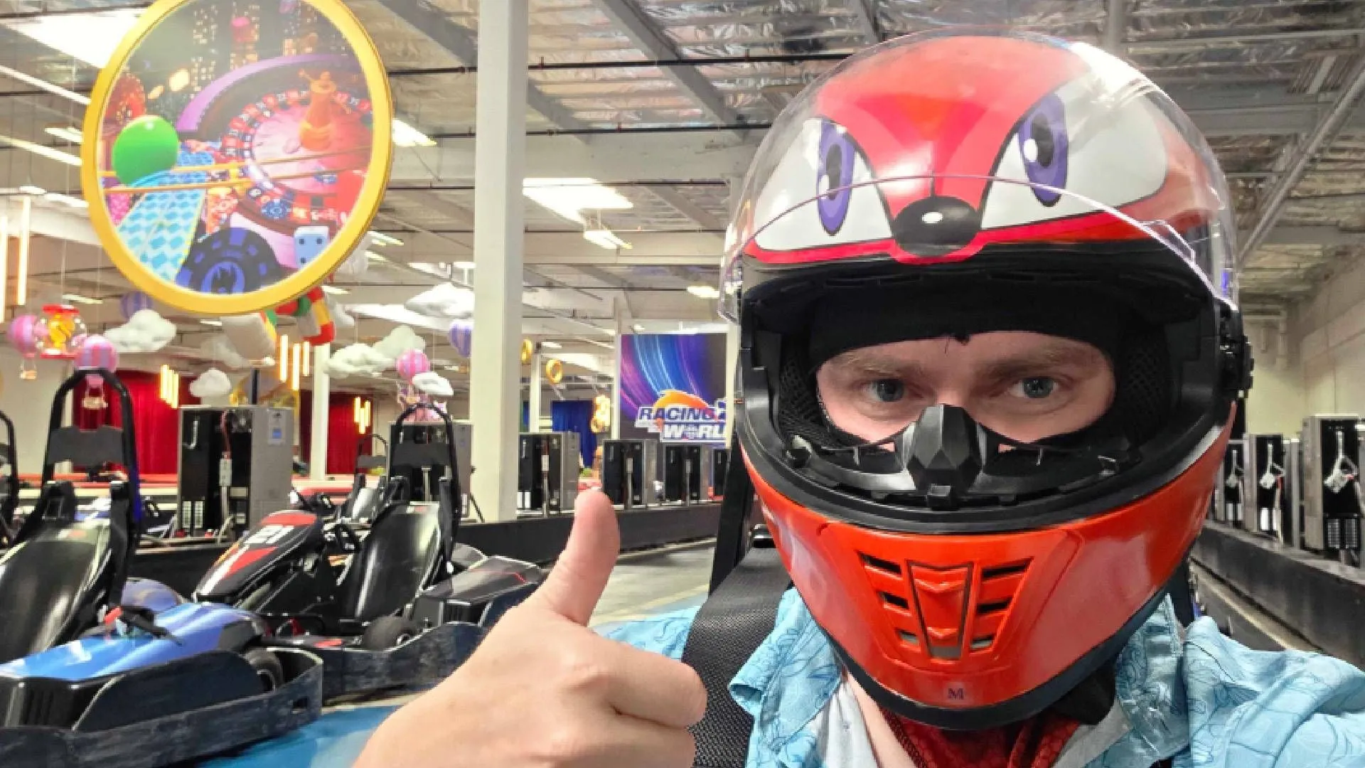 Game thủ trên đường đua go-kart K1 Speed được trang trí theo chủ đề Sonic Racing: Crossworlds, với tượng Knuckles bơm hơi phía trên giơ ngón cái
