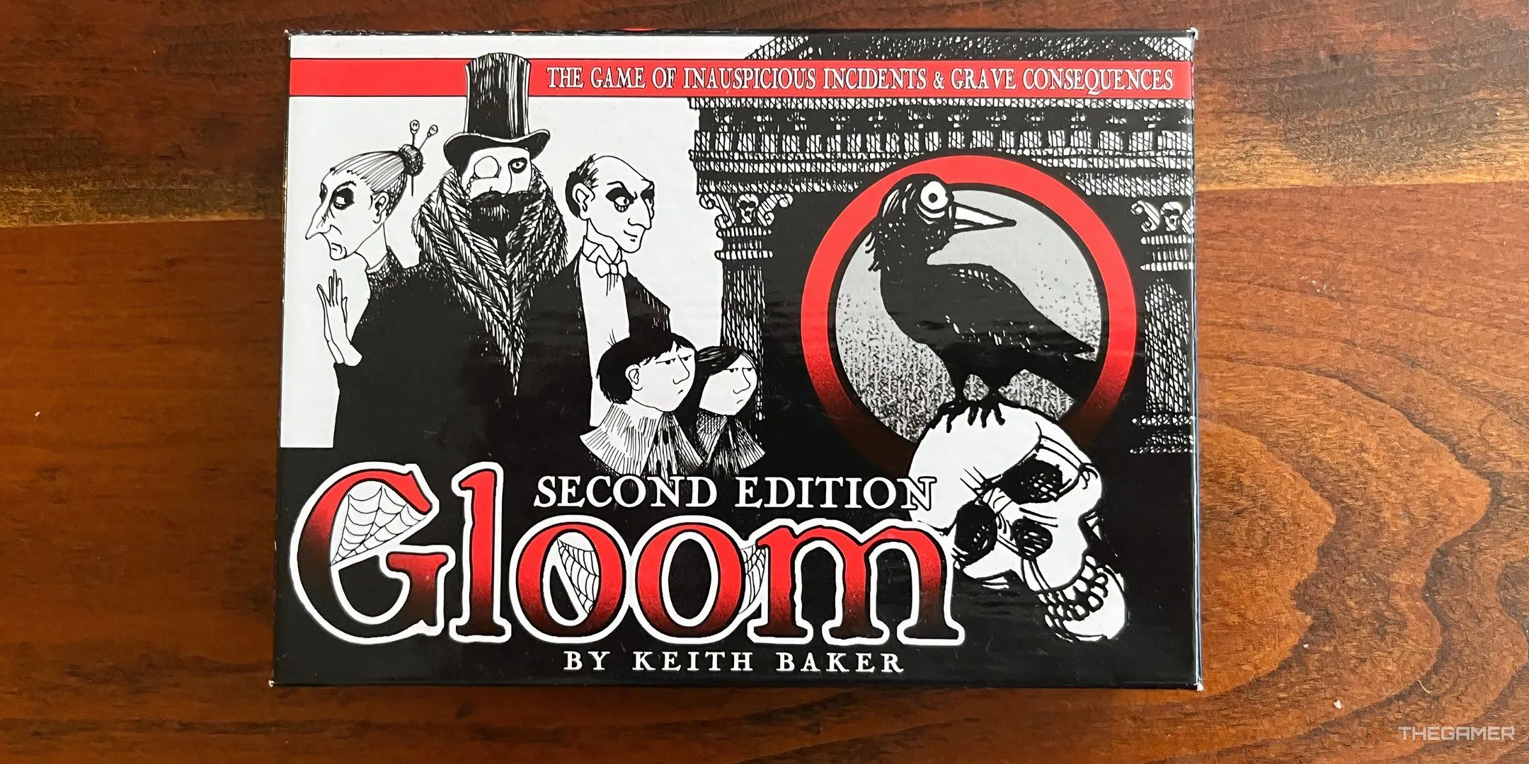 Hình ảnh hộp board game Gloom với phong cách Gothic, mô tả gia đình kỳ quái, phù hợp với game kể chuyện bi kịch