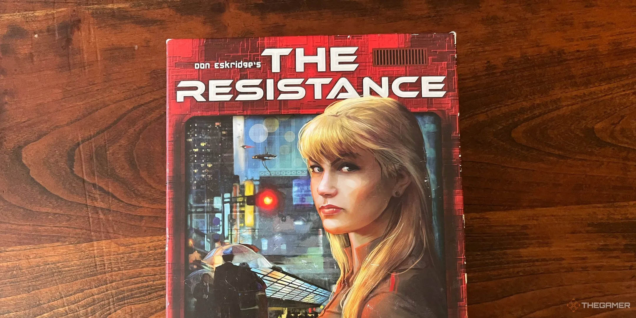 Hộp board game The Resistance với hình ảnh nữ điệp viên tóc vàng bí ẩn, thể hiện tính lừa dối xã hội
