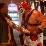 Sweet Tooth cầm dao dính máu đe dọa John Doe trong series Twisted Metal chuyển thể live-action