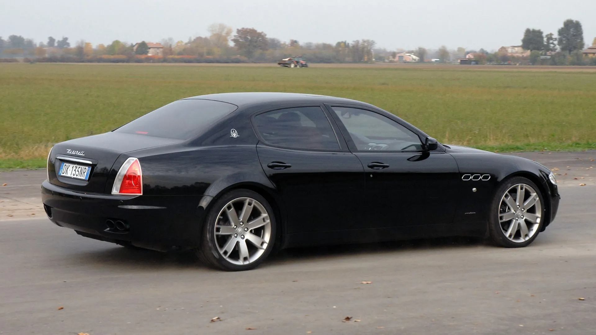 Góc sau 3/4 Maserati Quattroporte 2007 màu đen, minh họa thị trường xe cũ giá thấp so với thời mới.
