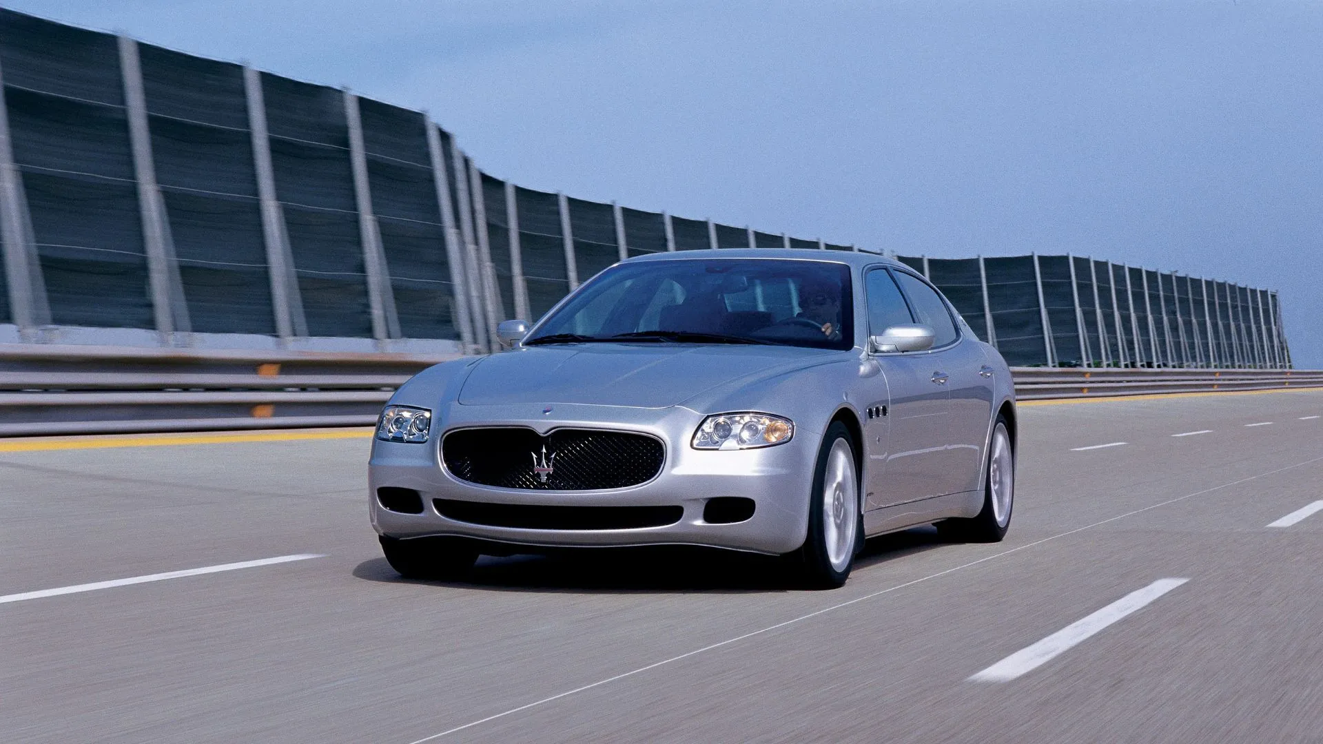 Góc trước 3/4 Maserati Quattroporte V (2003) màu bạc, minh họa thiết kế thế hệ thứ năm.