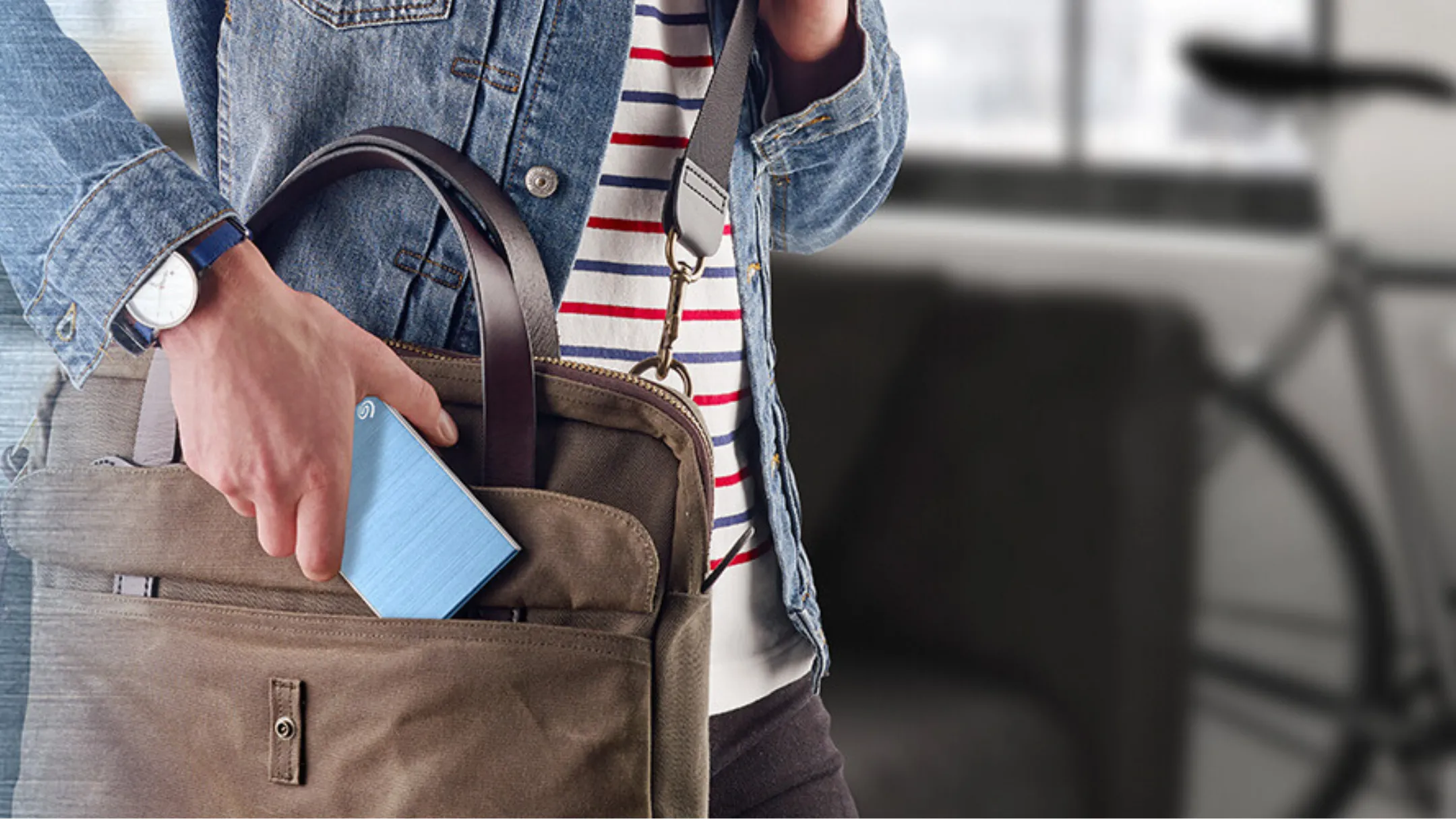 Người đưa ổ cứng Seagate Backup Plus Slim vào túi, minh họa tính di động của ổ 2TB